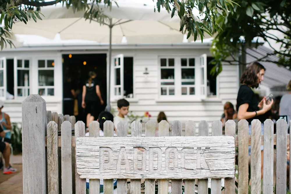 White weatherboard cottage and garden seating at Paddock Bakery